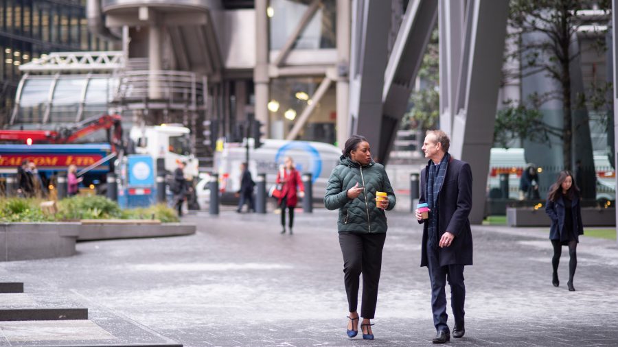 Commuters walking with re-useable coffee cups in central London