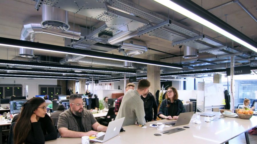 Colleagues interacting in a modern, open plan office