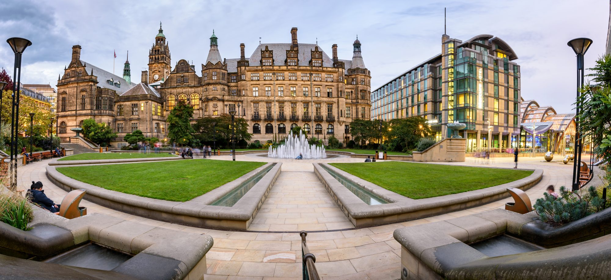 Wide shot of both old and modern buildings around a fountain in central Sheffield